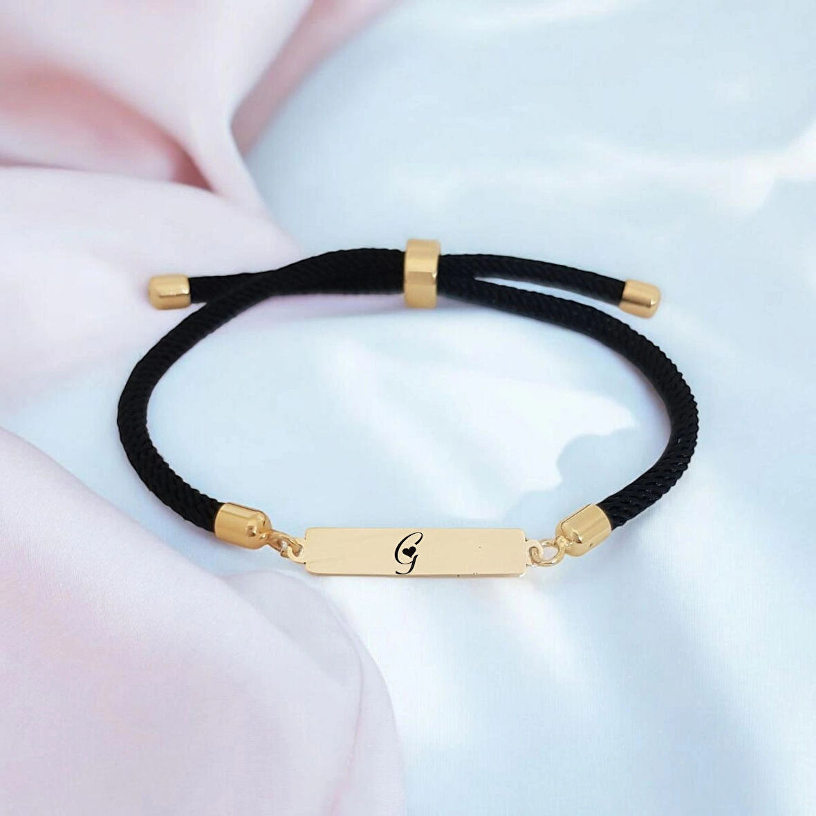 Göz Kamaştıran Dikdörtgen Motifli Siyah Örgülü 14 Ayar Altın Plakalı G Harfli Bileklik