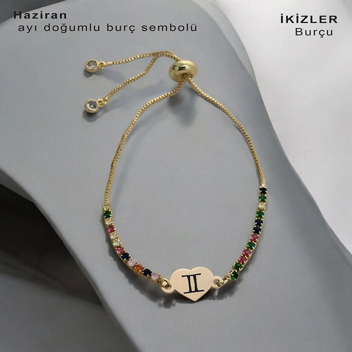Yazın başlangıcının keyfini çıkaran, Kalp Figürlü ve Renkli Taş Desenli 14 Ayar Altın Plakalı Haziran Bilekliği