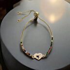 Masalsı bir dokunuş sunan, Kalp Figürlü ve Renkli Taş Desenli 14 Ayar Altın Plakalı Peri Bilekliği