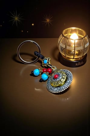 Metal Tibet Tarzı Enerji ve Şans Anahtarlığı – Turkuaz ve Kırmızı Taş Detaylı Spiritüel Tılsım