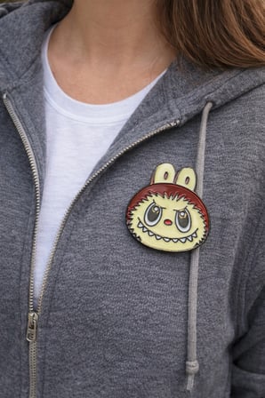 Sevimli Canavar Figürlü Metal Rozet – Yuvarlak Karakter Tasarımlı Çanta Aksesuarı Pin